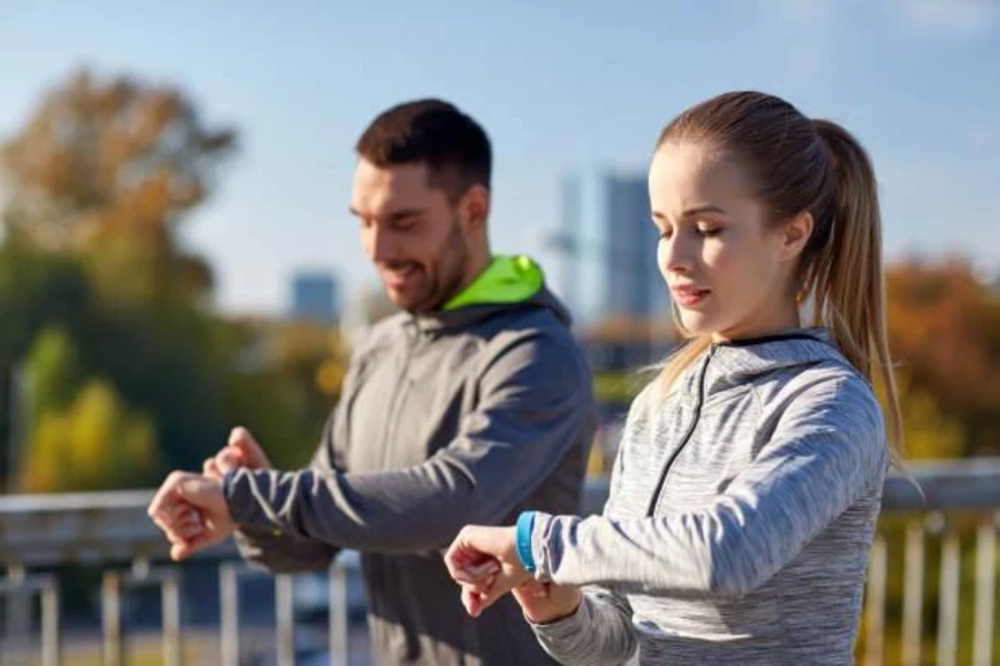 Un hombre y una mujer usando rastreadores de fitness.