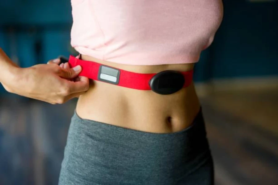 Une femme dans la salle de sport mettant un ECG portable