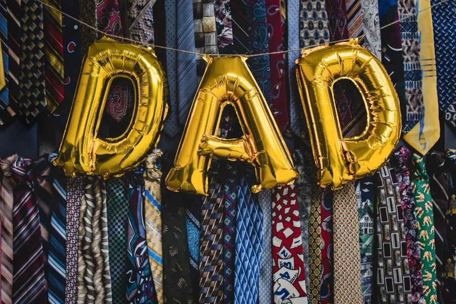 Papa buchstabiert in goldenen Luftballons