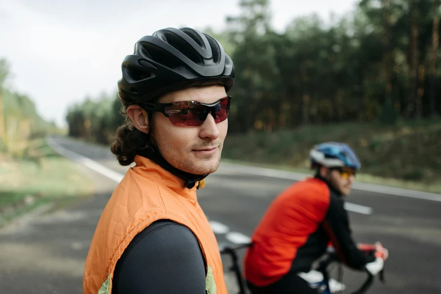 Hombre balanceando un par de gafas de montar y un casco