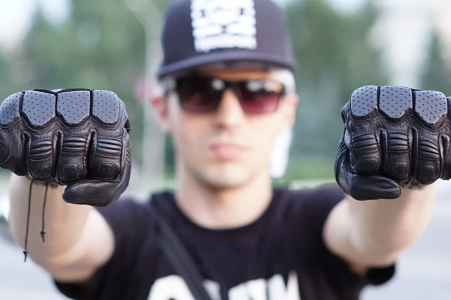 Man showcasing a pair of black riding gloves