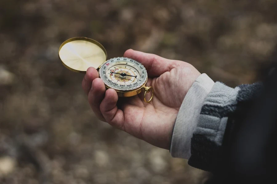 秋に金のケースに入ったコンパスを持つ人