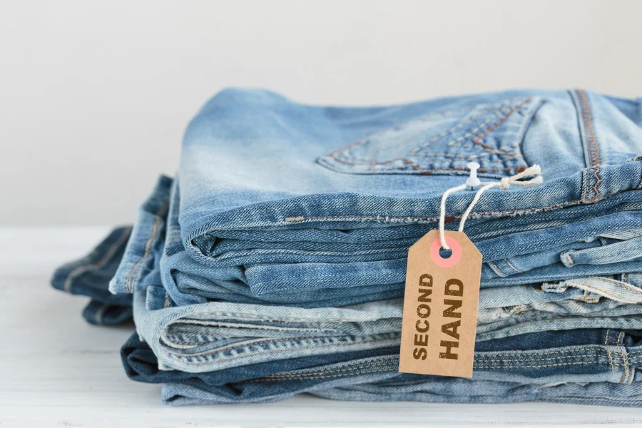 Stack of blue jeans with second hand tag