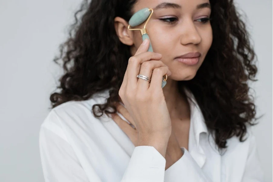 Señora usando un rodillo derma verde oliva en su cara