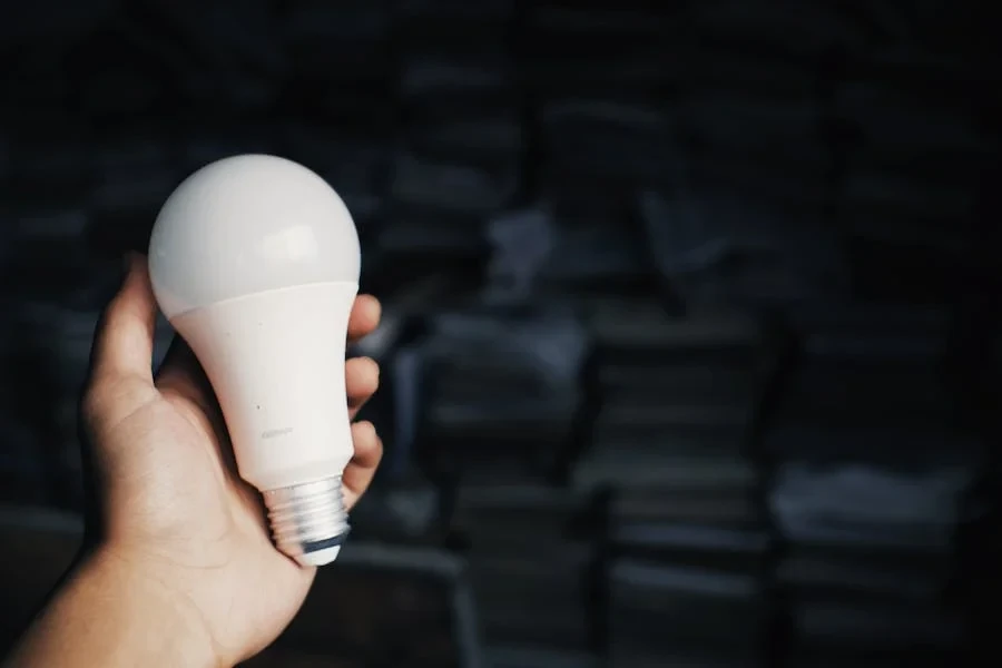 Persona sosteniendo una bombilla LED de pelota de golf.