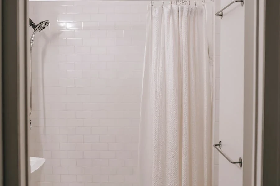 white textured curtain in a tiled bathroom