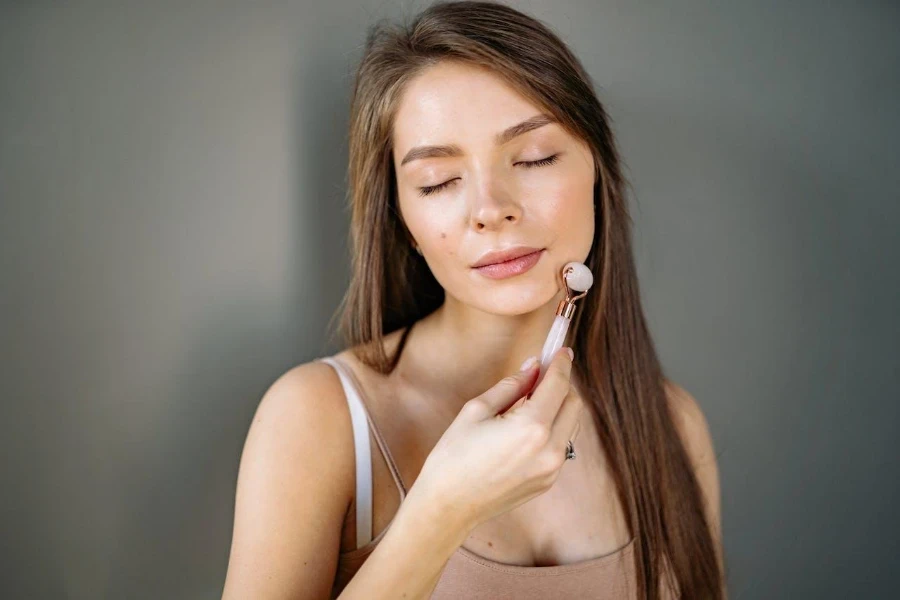 Mujer usando derma roller en su cara