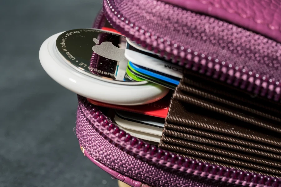 Apple AirTag being inserted in a small credit card wallet