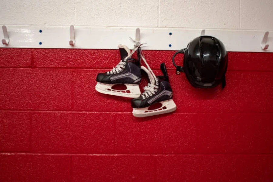 Patins de hóquei no gelo e capacete pendurados no vestiário