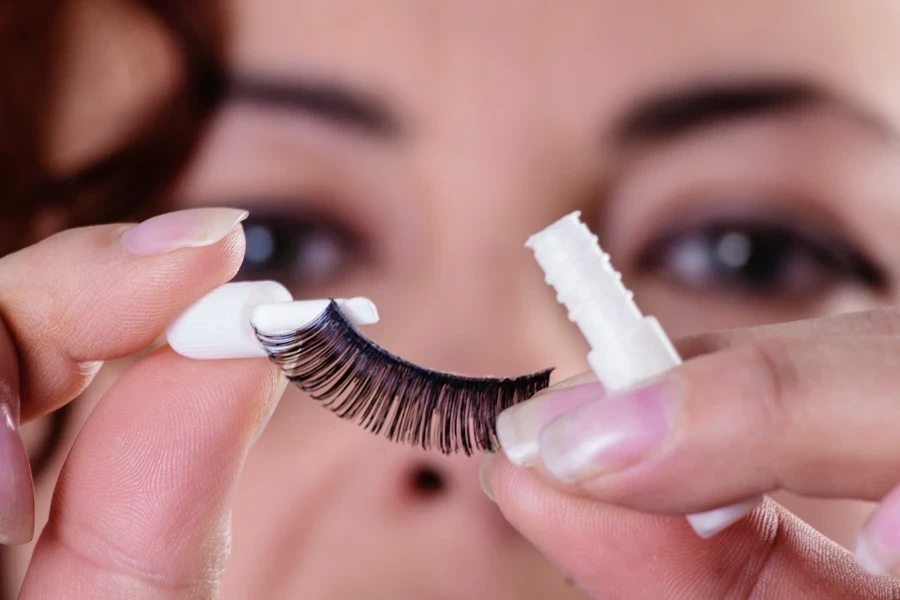 Lady applying glue to an eyelash extension