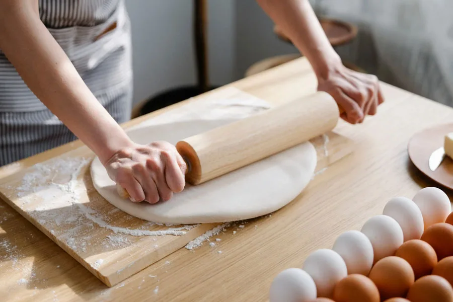 A baker kneading dough with a rolling pin