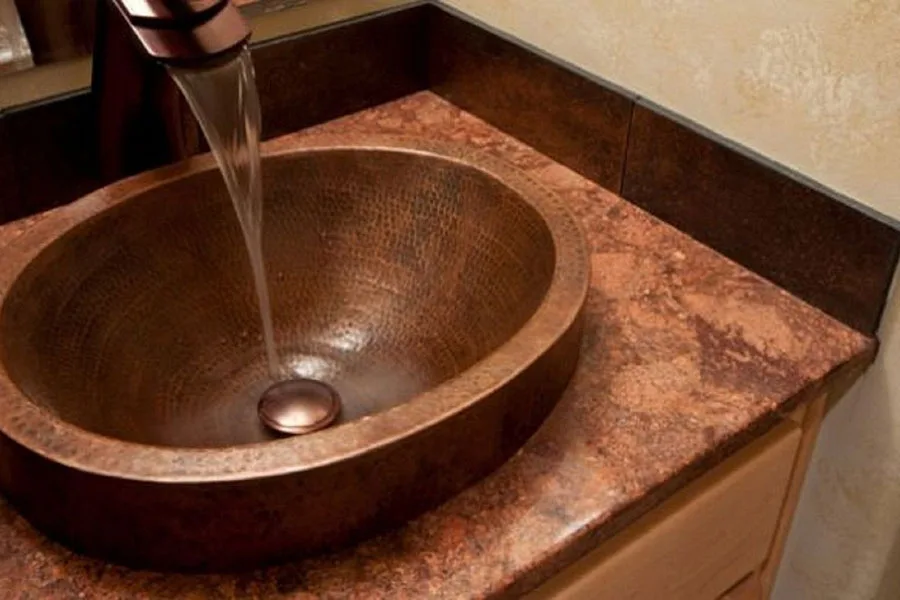 Une vasque en cuivre avec robinet en cuivre