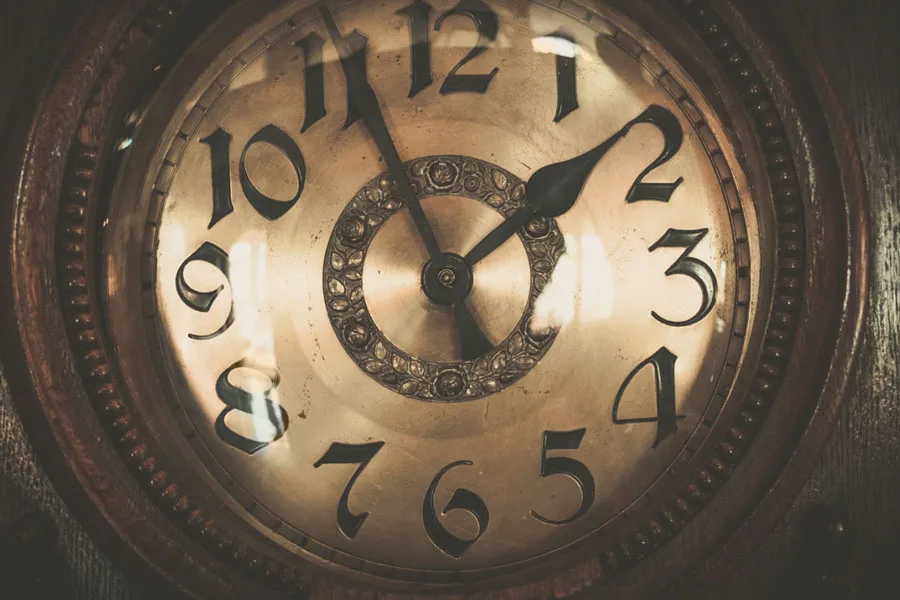 A dark brown vintage wall clock