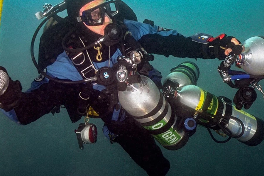Un plongeur tenant plusieurs bouteilles d'air