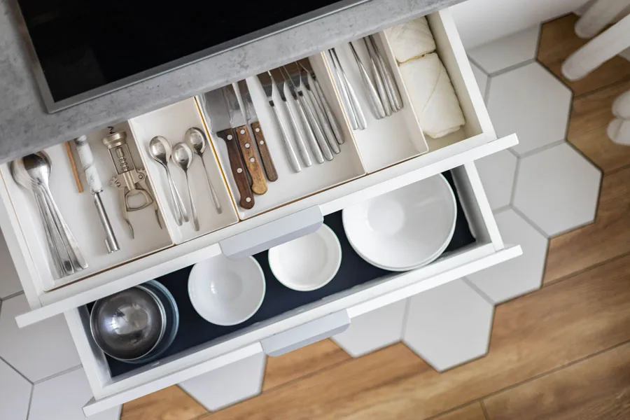 A drawer with a divider and kitchen utensils