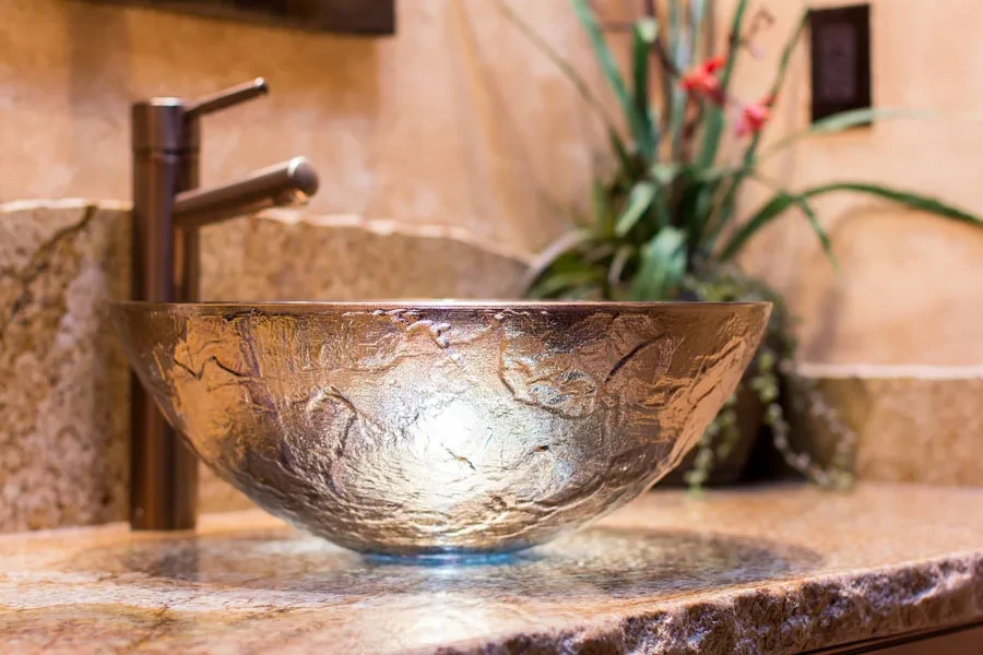 A glass vessel sink on a bathroom counter