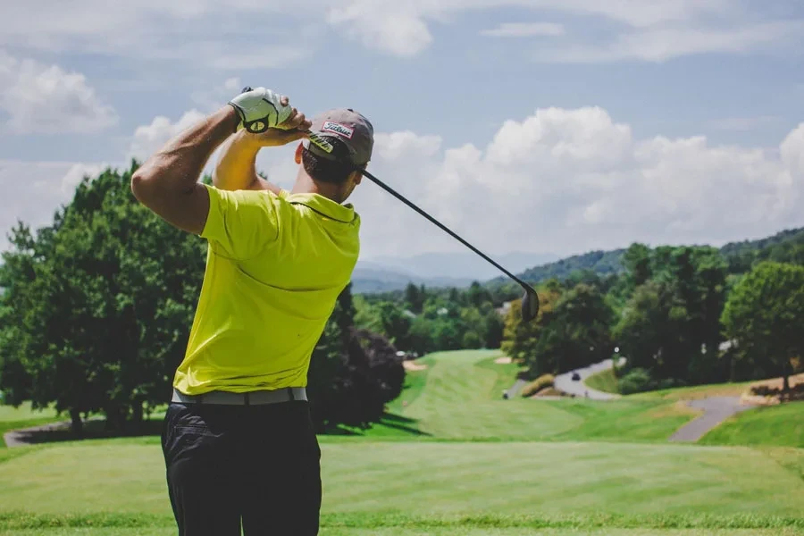 Un golfista golpeando una pelota de golf en mitad del giro.