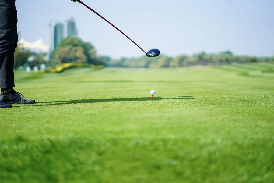 Um jogador de golfe se preparando para acertar uma bola de golfe com giro baixo