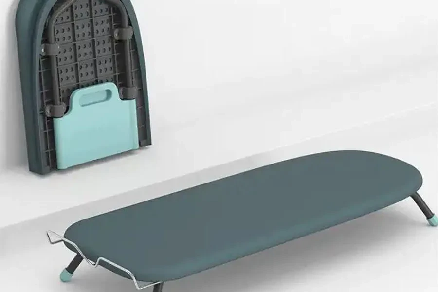 A green folding mini mesh ironing board