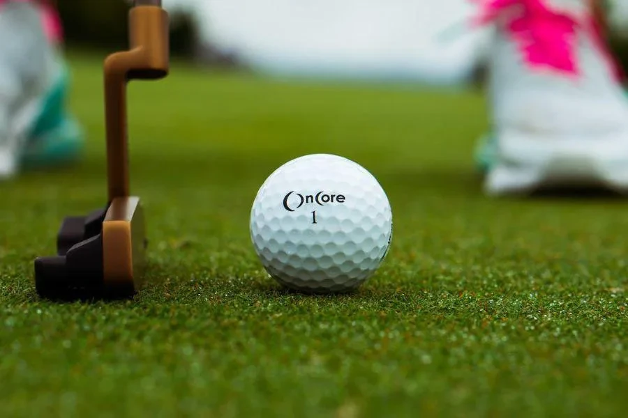 Una pelota de golf de mayor compresión sobre hierba verde.