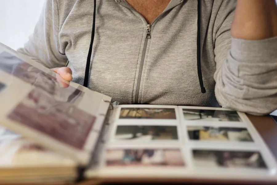 Una señora viendo un álbum de fotos autoadhesivo.