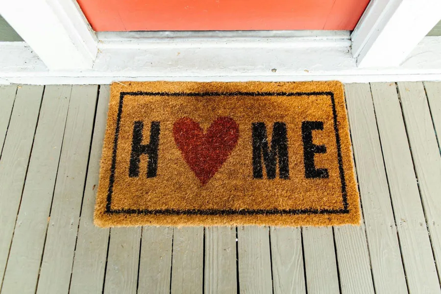 Eine hellbraune Fußmatte mit dem Text „Heimat und Liebe“.