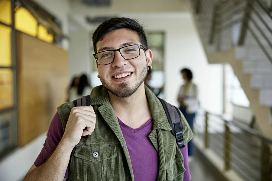 A man wearing a corduroy shirt over a purple t-shirt