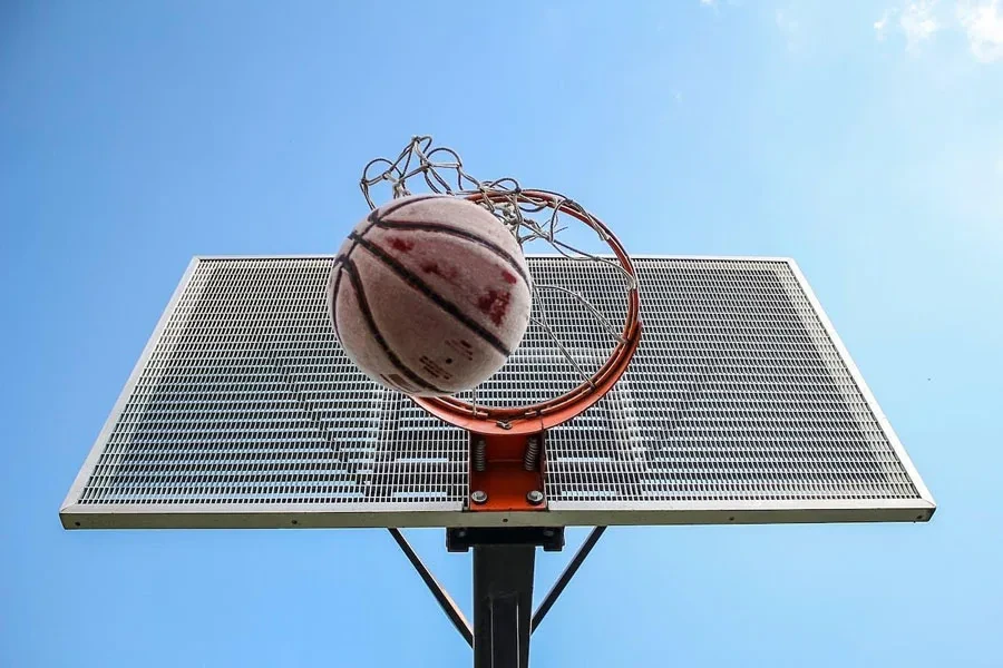 Una pelota de baloncesto de goma atravesando un aro de baloncesto.