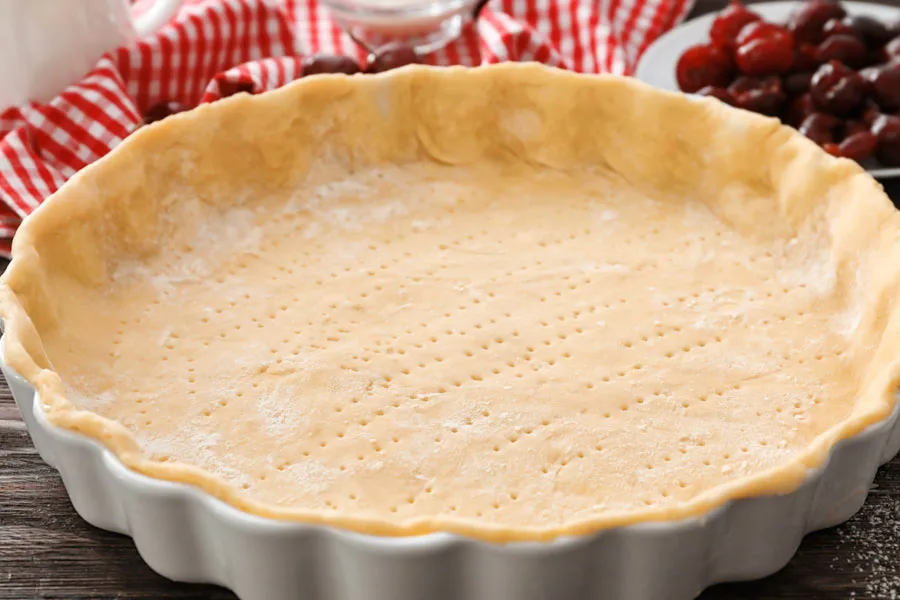 A white pie dish with dough