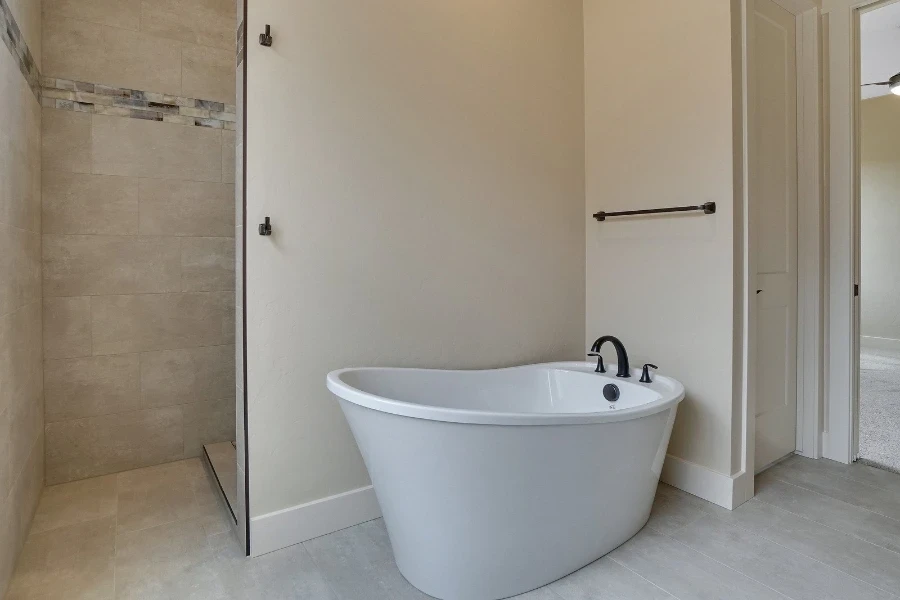 A white single-ended bathtub with black faucet