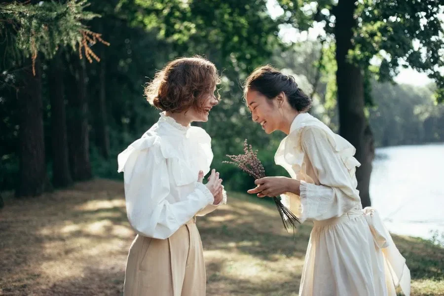 A woman in western dress with a woman in dress shirt