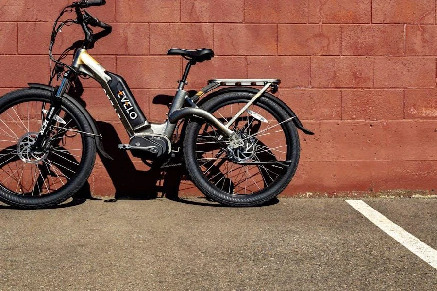 Una bicicleta eléctrica estacionada cerca de una pared de ladrillos.