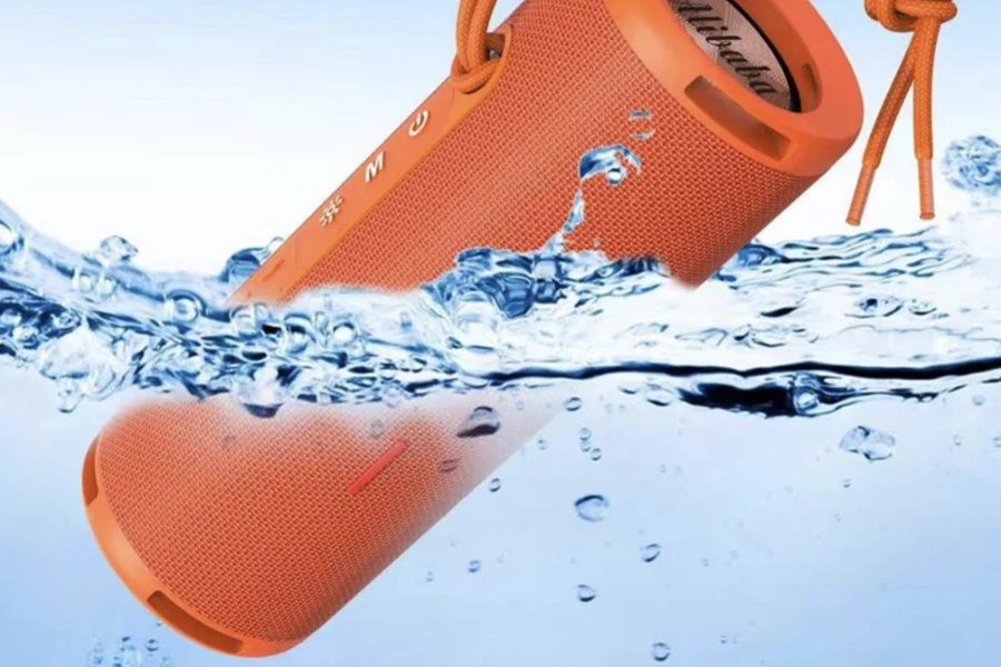 An orange-colored waterproof speaker dipped in water