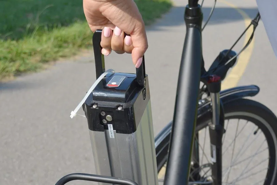 Anonymous person removing a battery pack from e-bike