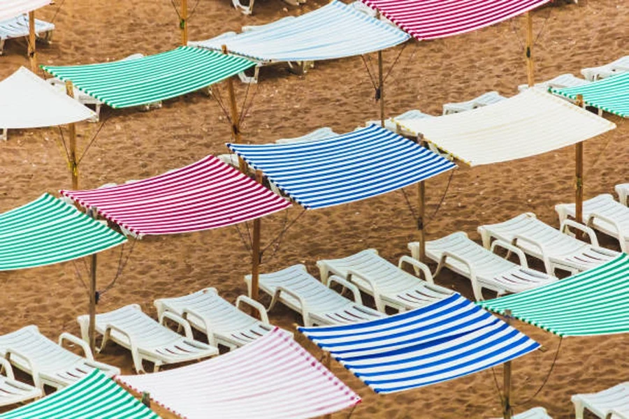 Parasol de plage installé sur des chaises de bronzage sur la plage