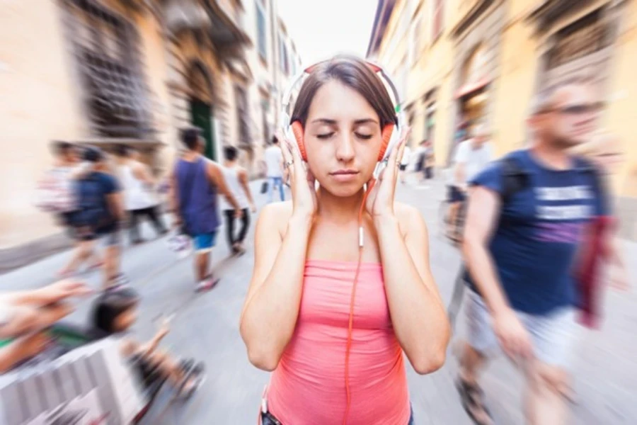 Schöne junge Frau hört Musik in der Stadt