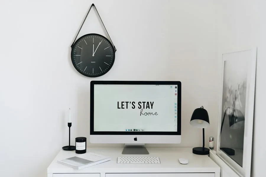 Black wall clock hung on a white wall