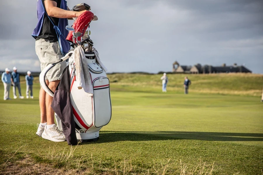 Caddy che si occupa della sacca da golf di un golfista