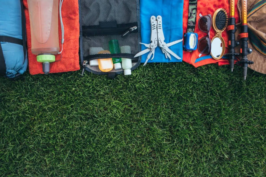 Campingausrüstung aufgereiht nebeneinander auf Gras