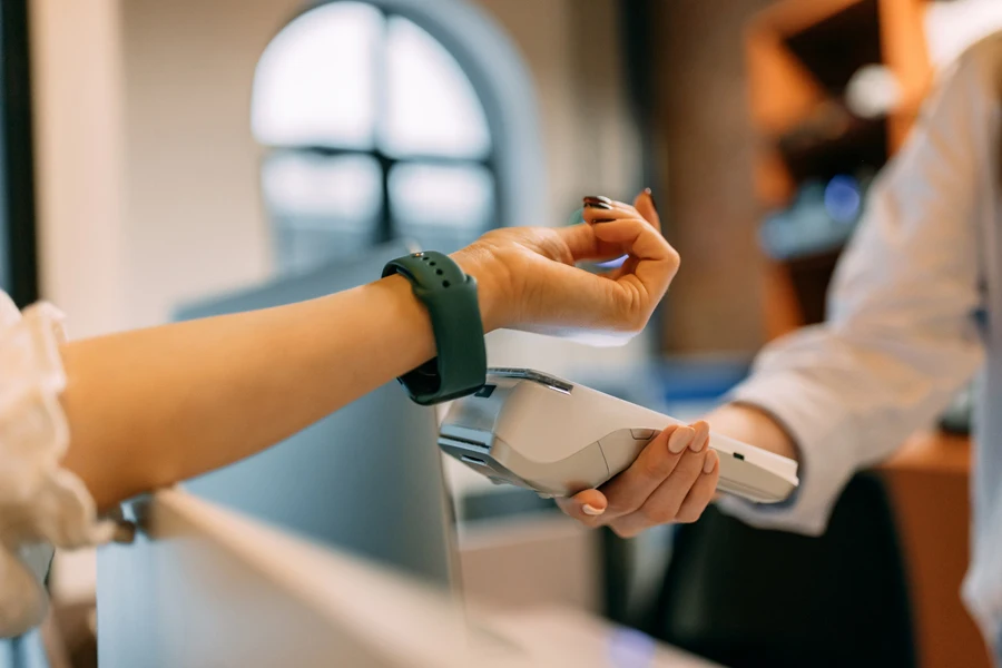 Cliente usando um smartwatch para efetuar um pagamento
