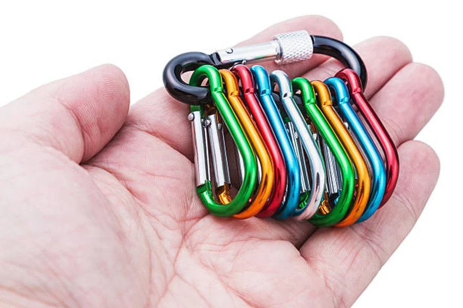 Tangan memegang berbagai warna klip carabiner untuk aksesoris