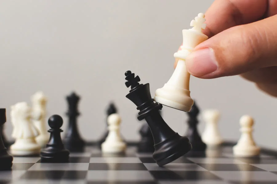 Mão do jogador movendo uma peça de xadrez