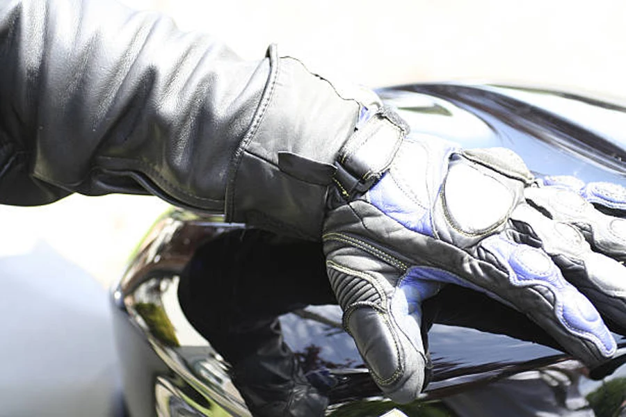 Hand mit ledernem Motorradhandschuh, der im Sonnenlicht getragen wird