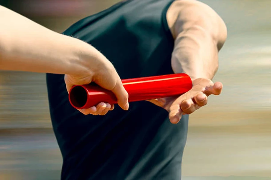 Handoff of carbon fiber baton by two men during relay