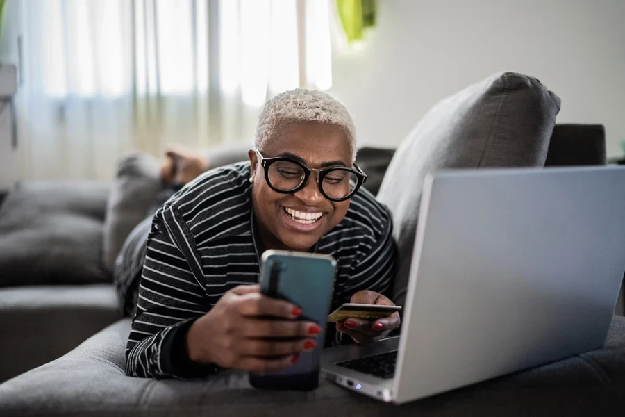 Femme heureuse, faire du shopping en ligne à la maison