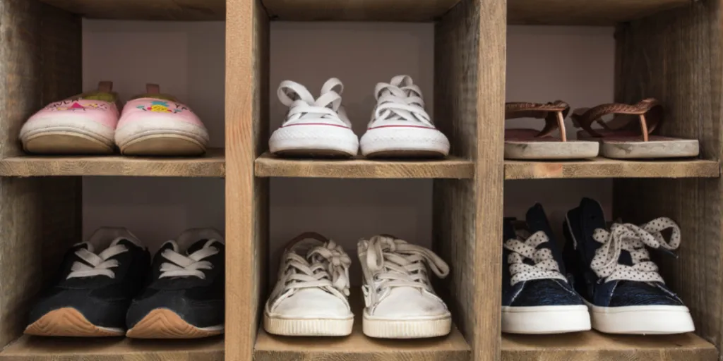 Rak sepatu kayu dalam ruangan dengan kompartemen berbeda