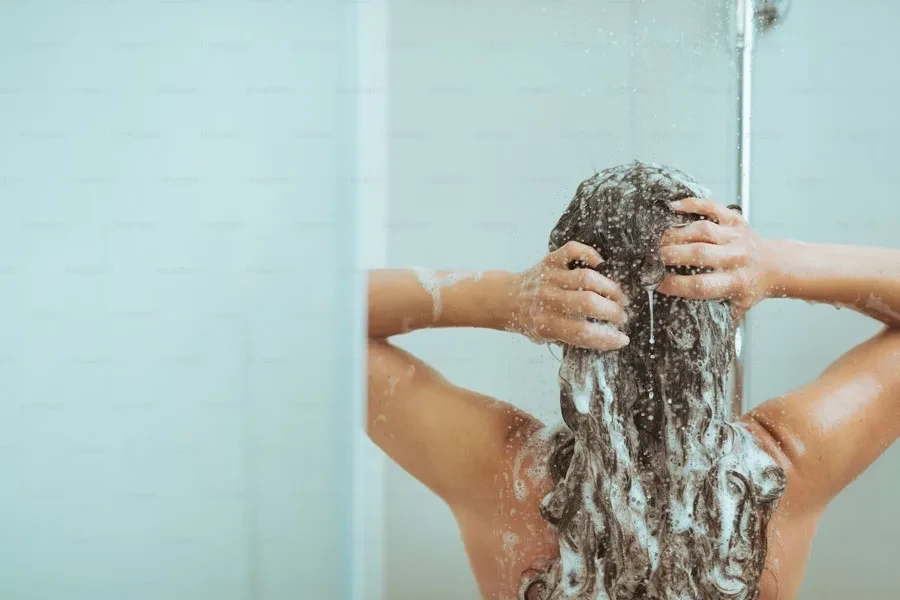 Señora lavándose el pelo en la ducha