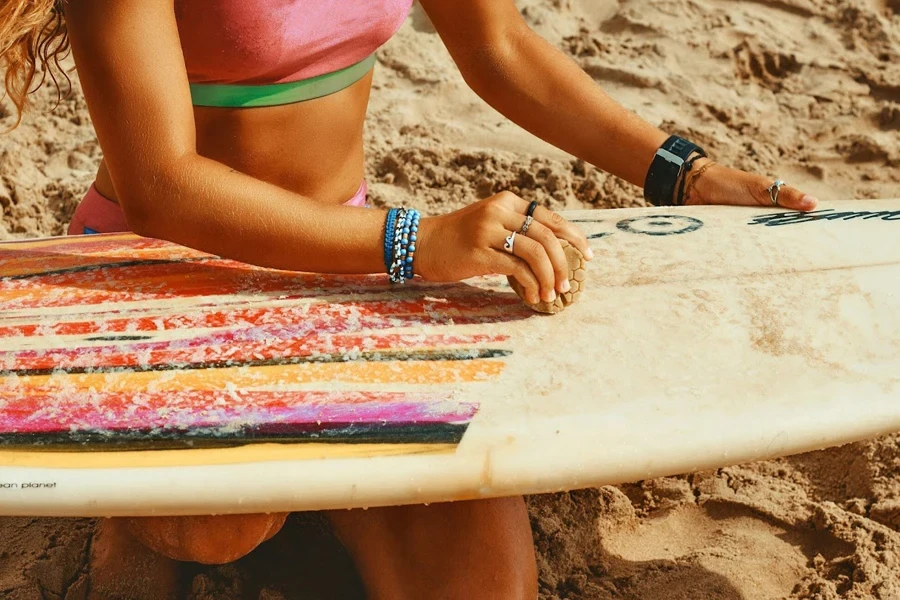 Señora encerando su skimboard de madera