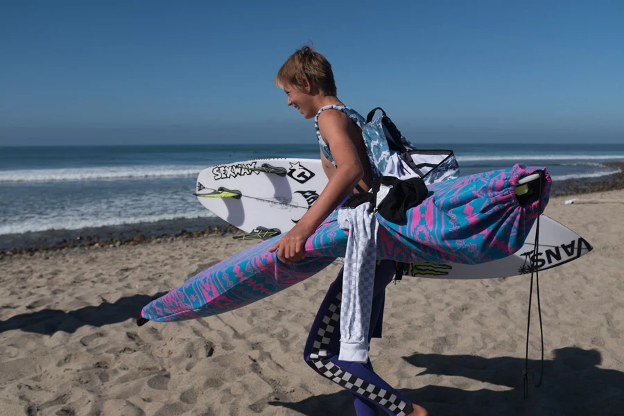 Homem carregando uma prancha de surf em capas elásticas