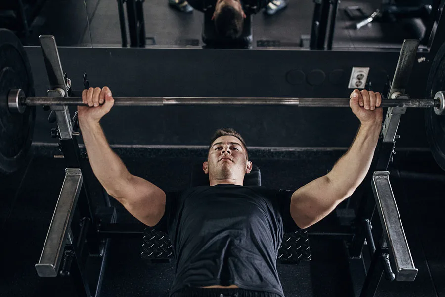 Man in black shirt working out on a weight bench